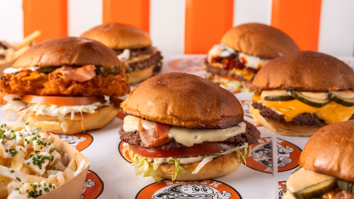 Row of Smasheat burgers and loaded fries on branded wrapping paper